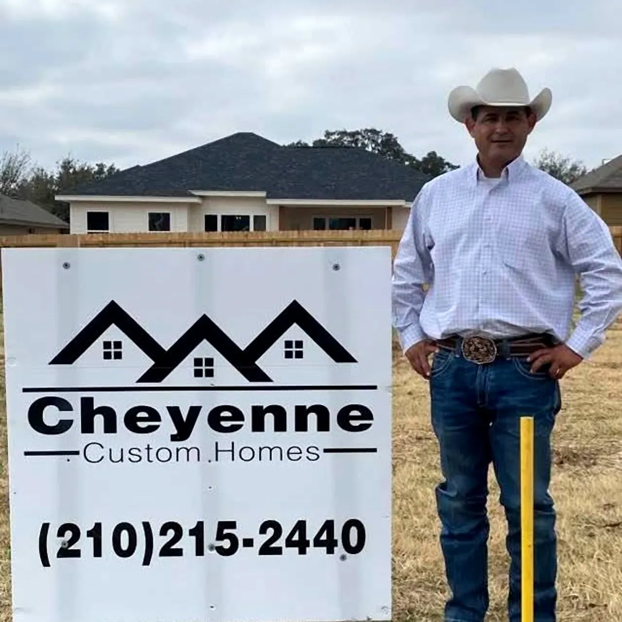Darran Salmeron of Cheyenne Custom Homes beside the company sign on a lot